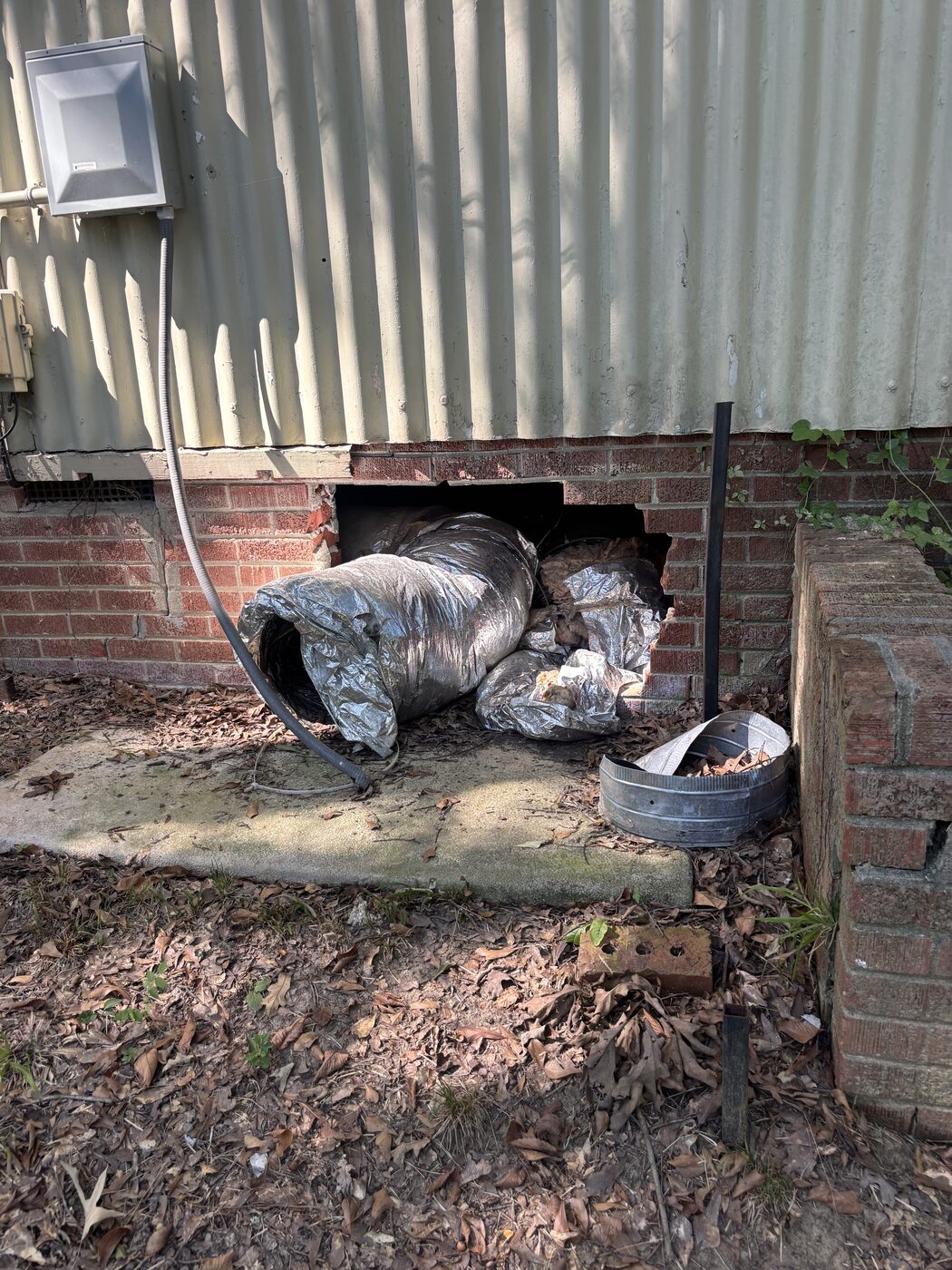 Crawlspace opening with HVAC flex duct pulled out